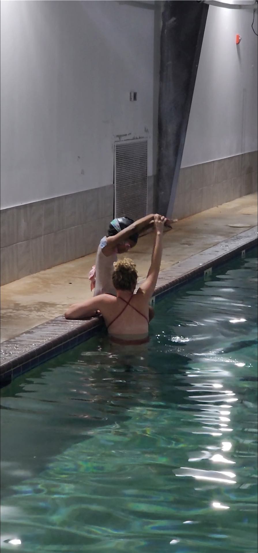 Instructor demonstrating proper breathing technique to a young swimmer