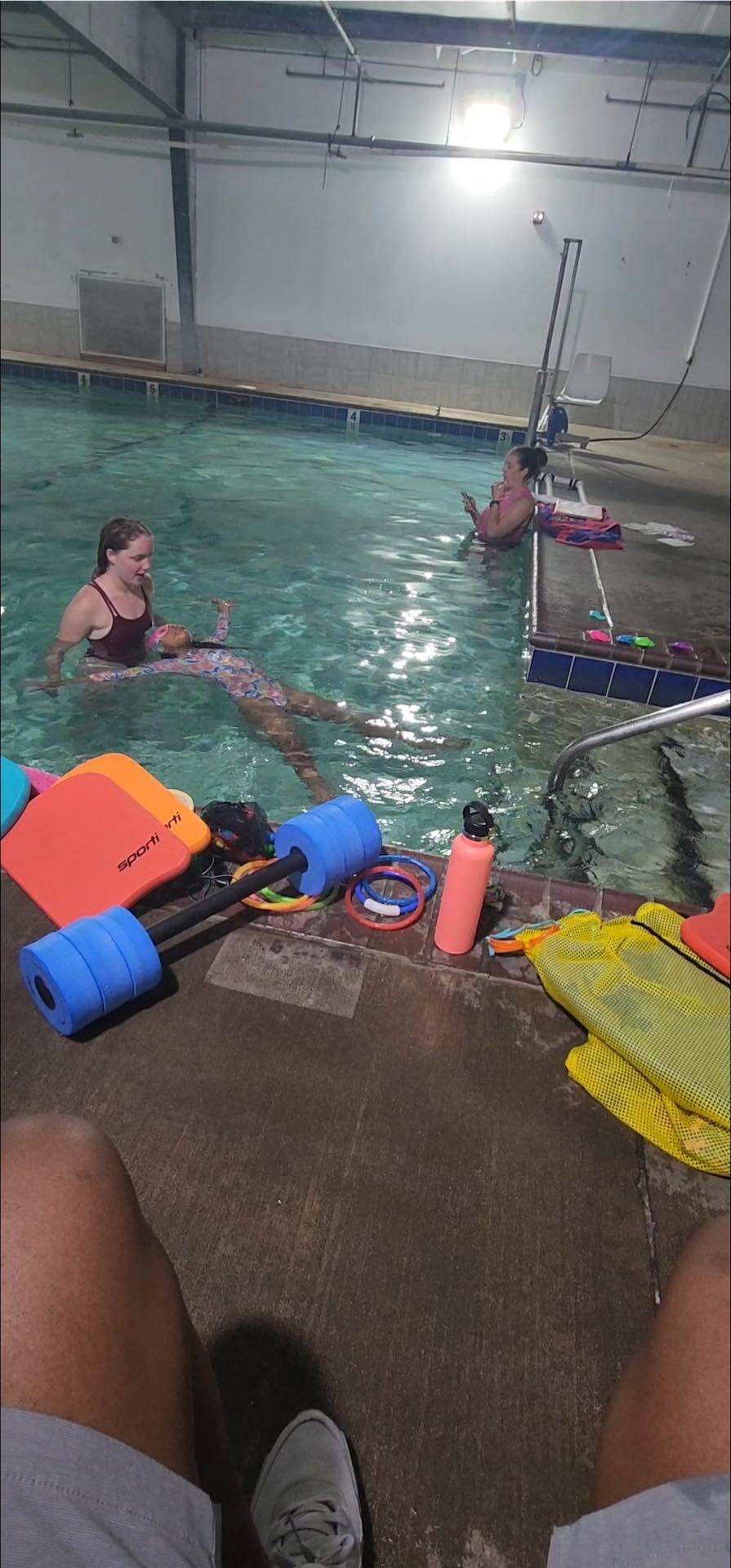 Young swimmer practicing kicking with a kickboard in Edmond, OK
