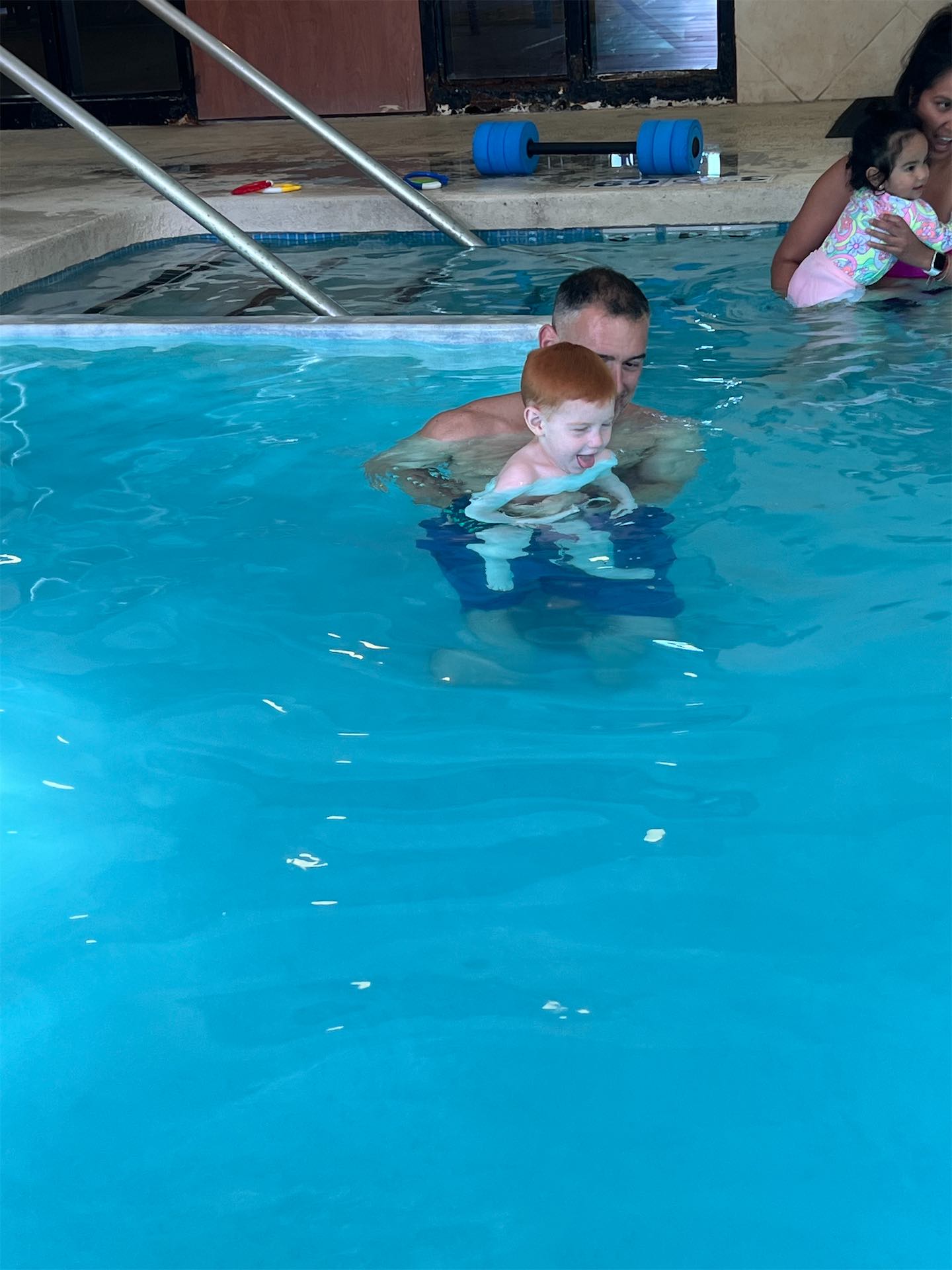 Swim instructor helping a nervous child build confidence in the water