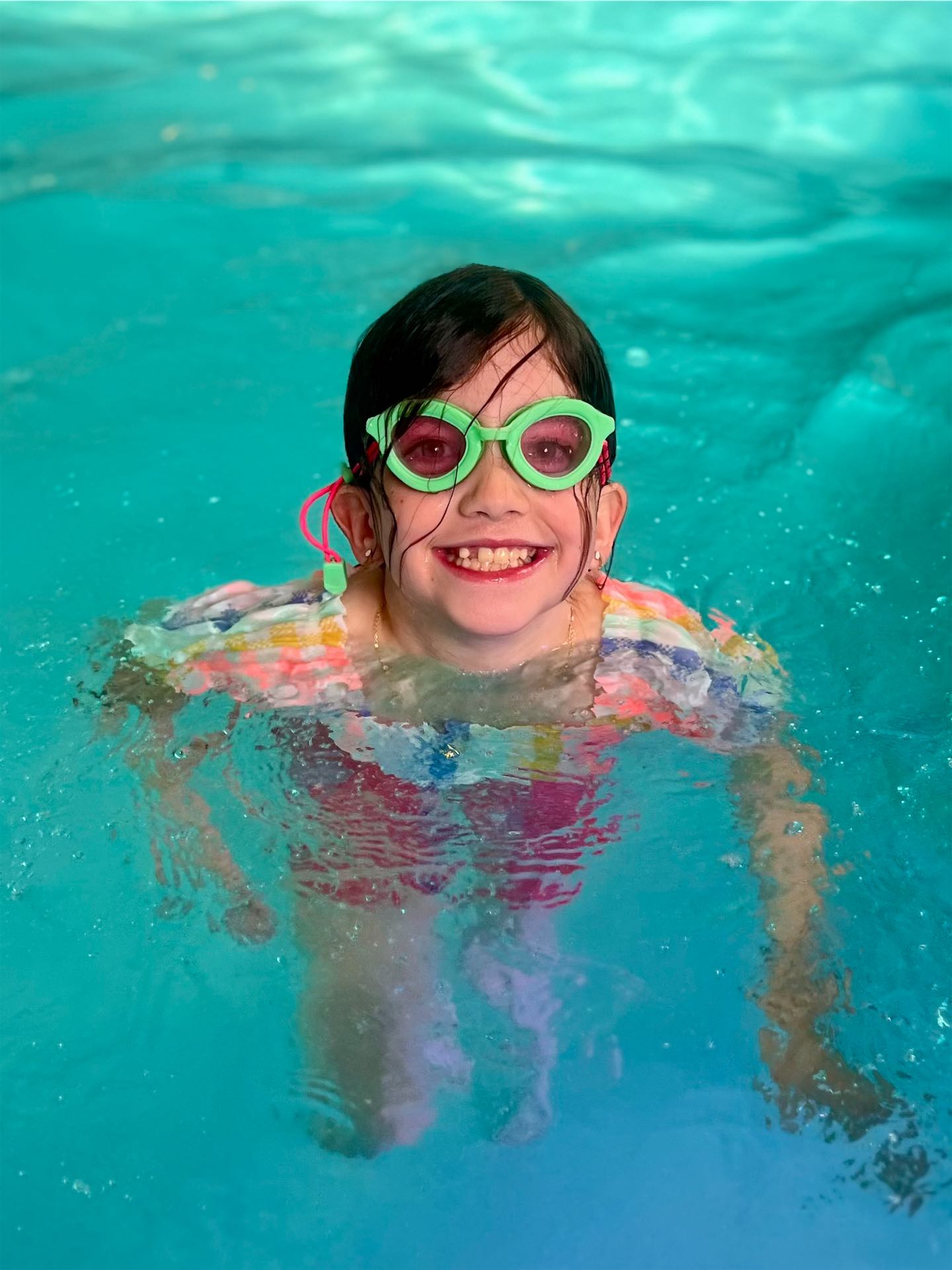 Group class of young swimmers practicing breaststroke kicks in OKC