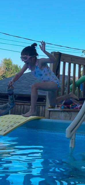 Toddler blowing bubbles underwater during a beginner swim lesson